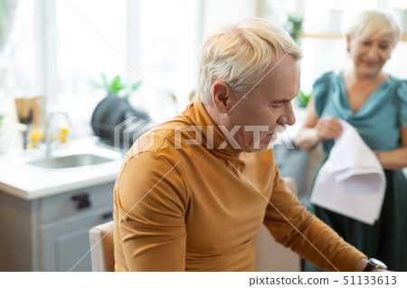 Stylish handsome attractive grey-haired bearded man sitting at the kitchen. 51133613