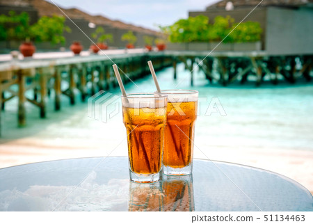 Iced tea against tropical Overwater Bungalow Resort. 51134463