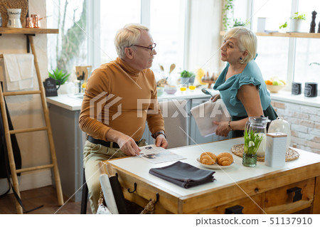 Stylish well-dressed white-haired couple discussing menu for a romantic evening. 51137910