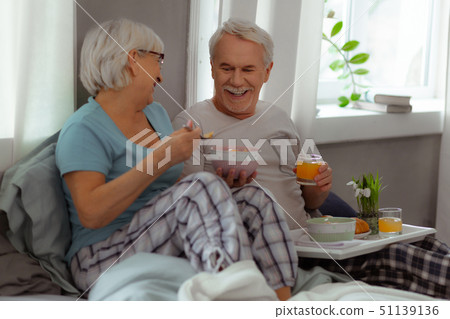 Joyful spouses sharing a laugh and enjoying breakfast Joyful spouses sharing a laugh and enjoying breakfast 51139136