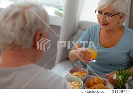 Happy woman enjoying breakfast in the bed with her spouse Happy woman enjoying breakfast in the bed with her spouse 51139764