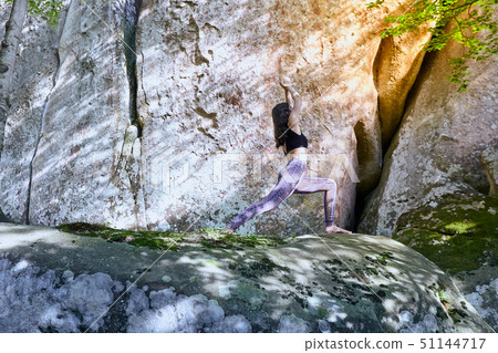 Young girl in mountains doing yoga exercise outdoor. Young girl in mountains doing yoga exercise outdoor. 51144717
