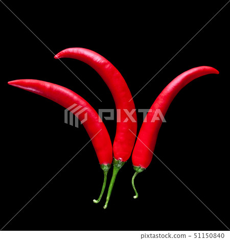 three red peppers on a black background laid out in the form of a jester's cap. 51150840