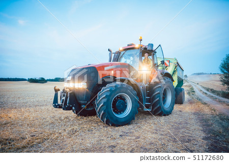 Agricultural machinery and tractor on a harvested field 51172680