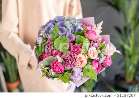 Small Beautiful bouquet of mixed flowers in woman hand. Floral shop concept . Beautiful fresh cut 51187207