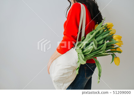 Young woman with yellow tulip spring flowers. Young woman with yellow tulip spring flowers. 51209000