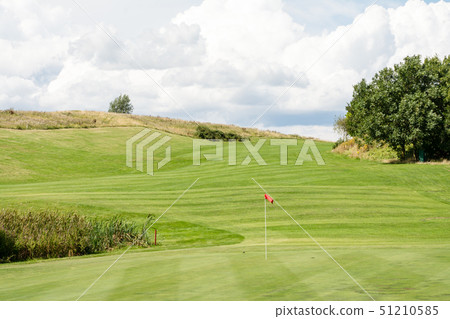 Golf course in early summer Green and fairway with red flag 51210585