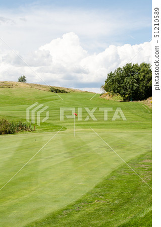 Golf course in early summer Green and fairway with red flag 51210589