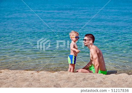 Toddler boy on beach with father Toddler boy on beach with father 51217836