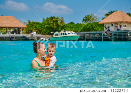 Toddler boy on beach with mother 51222734