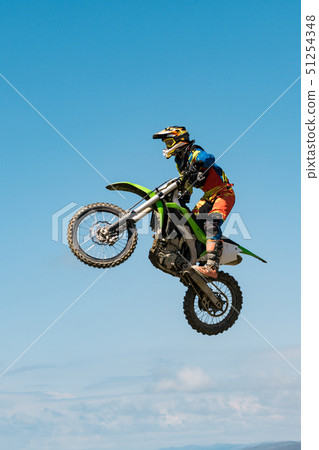 A picture of a biker making a stunt and jumps in the air A picture of a biker making a stunt and jumps in the air 51254348