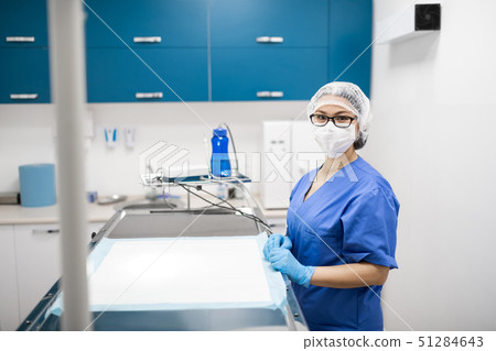 Vet wearing blue uniform and mask preparing for surgery 51284643