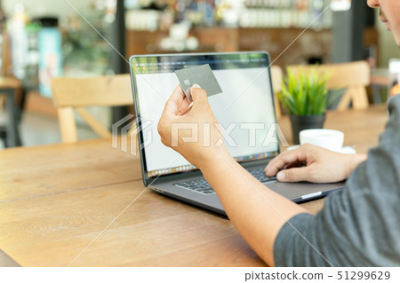 Businessman online working hand holding credit card and using laptop in cafe. 51299629
