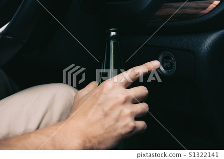 The man hand is holding a beer bottle and pressing The man hand is holding a beer bottle and pressing 51322141