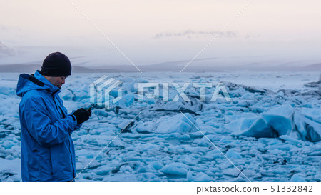 Asian man using smart phone at jokulsarlon, 51332842