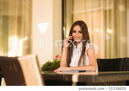 Long hair female use phone while she is waiting for the order in cafe Long hair female use phone while she is waiting for the order in cafe 51338628