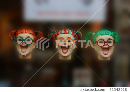 Three colourful fake laughing woman heads floating 51342918