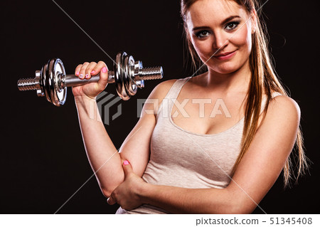 athletic woman working with heavy dumbbells 51345408