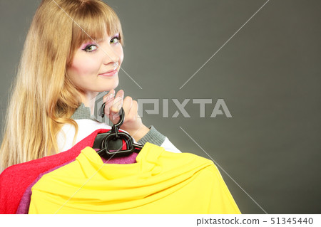 woman customer holding hangers with clothes 51345440