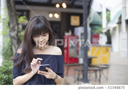 pretty asian woman enjoy with her smart phone 51348675