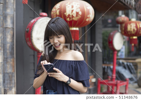 smiling young asian woman enjoy with smart phone 51348676