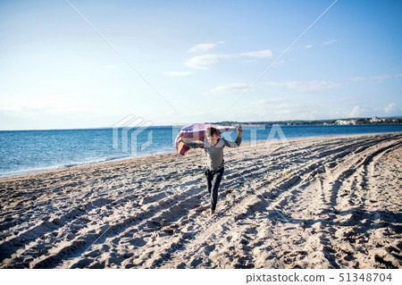 A small boy playing outdoors on sand beach. 51348704