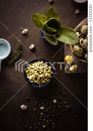 Mung bean sprouts in a bowl on dark wooden board 51350282