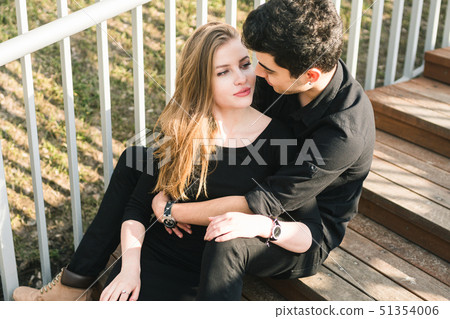 Beautiful young multiracial couple, student couple in love, sit wooden staircase in the city 51354006