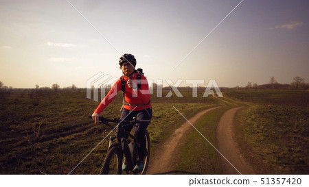 Athletic Caucasian woman eats protein bar ride on mountain bike on nature. Young sporty woman 51357420