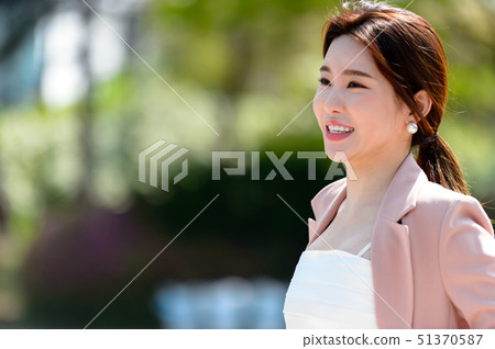 一個充滿自信,生活方式,在公園休息的韓國女人的表達 一個充滿自信,生活方式,在公園休息的韓國女人的表達 51370587