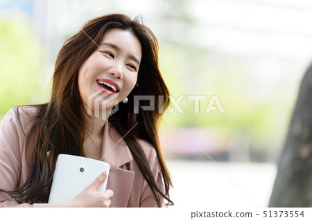 一個充滿自信,生活方式,在公園休息的韓國女人的表達 一個充滿自信,生活方式,在公園休息的韓國女人的表達 51373554