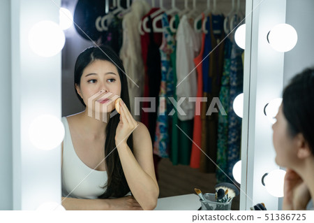 actress apply blush on her face with powder puff 51386725