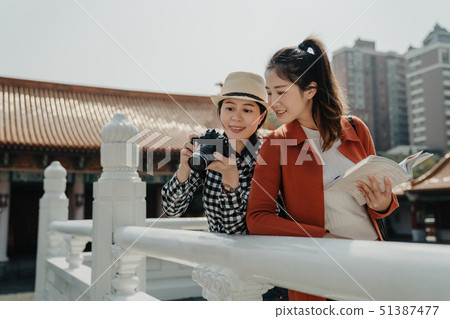 two friend leaning on white marble stone railings 51387477