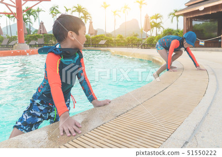 Two Asian siblings in playing together in Water 51550222