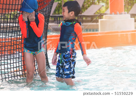 Two Asian siblings in playing together in Water 51550229