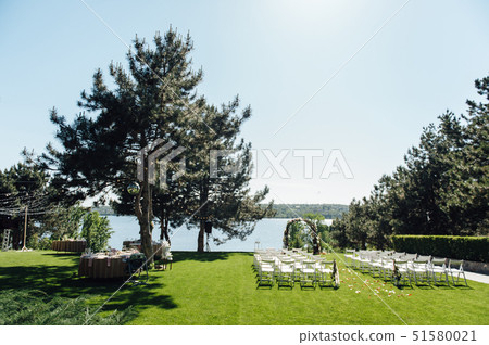 beautiful arch for the wedding ceremony in the park with white chairs for guests beautiful arch for the wedding ceremony in the park with white chairs for guests 51580021