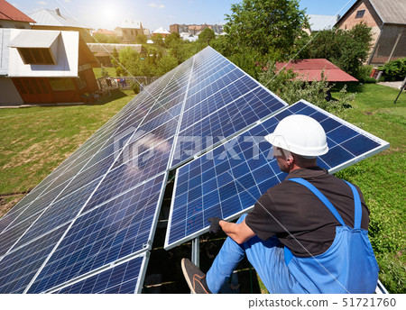 Professional worker installing solar panels on the green metal construction Professional worker installing solar panels on the green metal construction 51721760