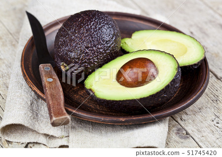 Fresh organic avocado on ceramic plate and knife 51745420