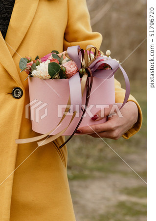 Beautiful woman holding pink box with flowers. Gift to Women's Day. Agency floral design, place text 51796720