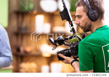The concept of the creation of TV, video content, backstage. A professional cameraman is filming on 51801149