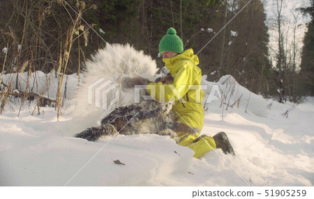 Woman bathes shaggy dog in the snow Woman bathes shaggy dog in the snow 51905259