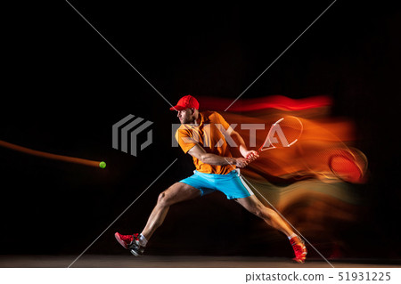 One caucasian man playing tennis on black background 51931225