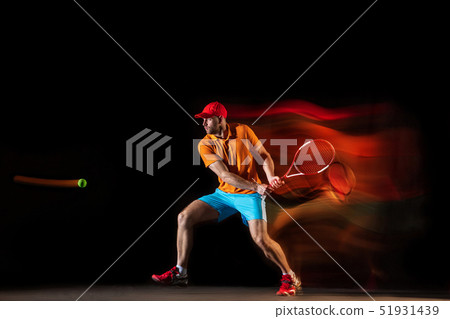 One caucasian man playing tennis on black background 51931439