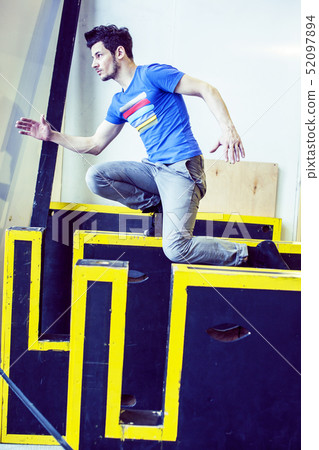 young handsome man doing parkour in gym inside, lifestyle sport people concept 52097894