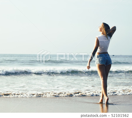 young pretty blond woman at seacoast walking relaxing, fashion lady at sunset 52101562