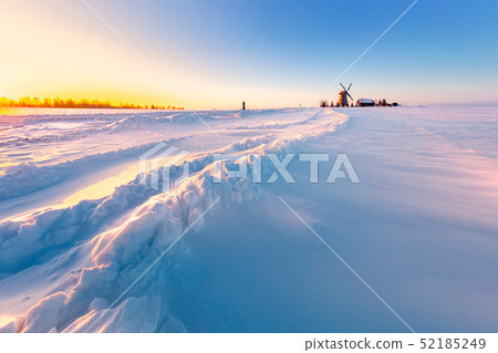 Wooden windmill on background winter sunrise. Dudutki village, Belarus Wooden windmill on background winter sunrise. Dudutki village, Belarus 52185249