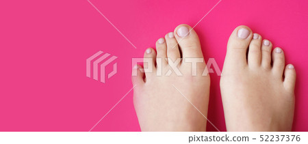 Young perfect groomed womans feet on pink background. Care about nails Young perfect groomed womans feet on pink background. Care about nails 52237376