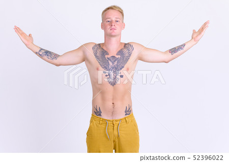 Young handsome shirtless man with tattoos raising arms 52396022