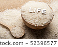 Close up view of rice in a wooden spoon and bowl 52396577