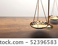 Gold brass balance scale on wooden desk 52396583
